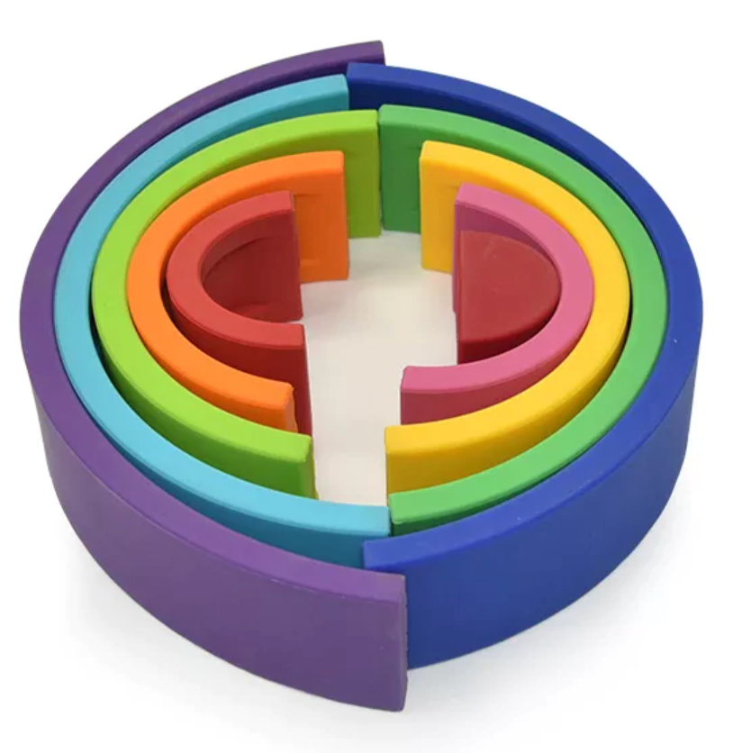 Arco-íris de encaixe feito de tiras de silicone nas cores vinho, vermelho, rosa, laranja, amarelo, verde limão, verde, azul claro, azul escuro, roxo. Peças desmontáveis para brincar e empilhar e encaixar. Peças colocadas em outro formato para ilustrar ourtos modos de brincar.