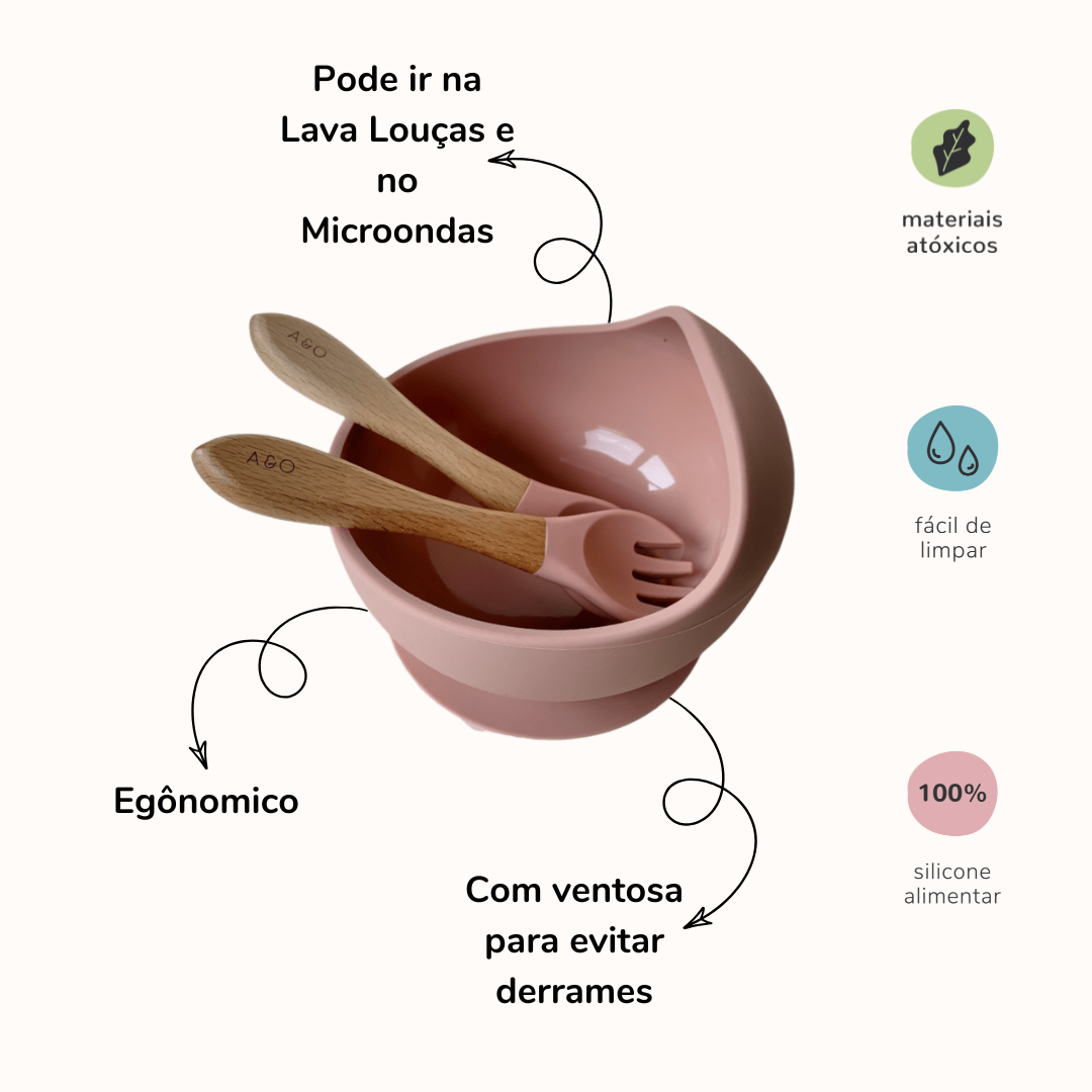 Um bowl com uma colher e um garfo com cabo de madeira e ponteira de silicone na cor rosa blush. A imagem contem informações sobre o o produto.